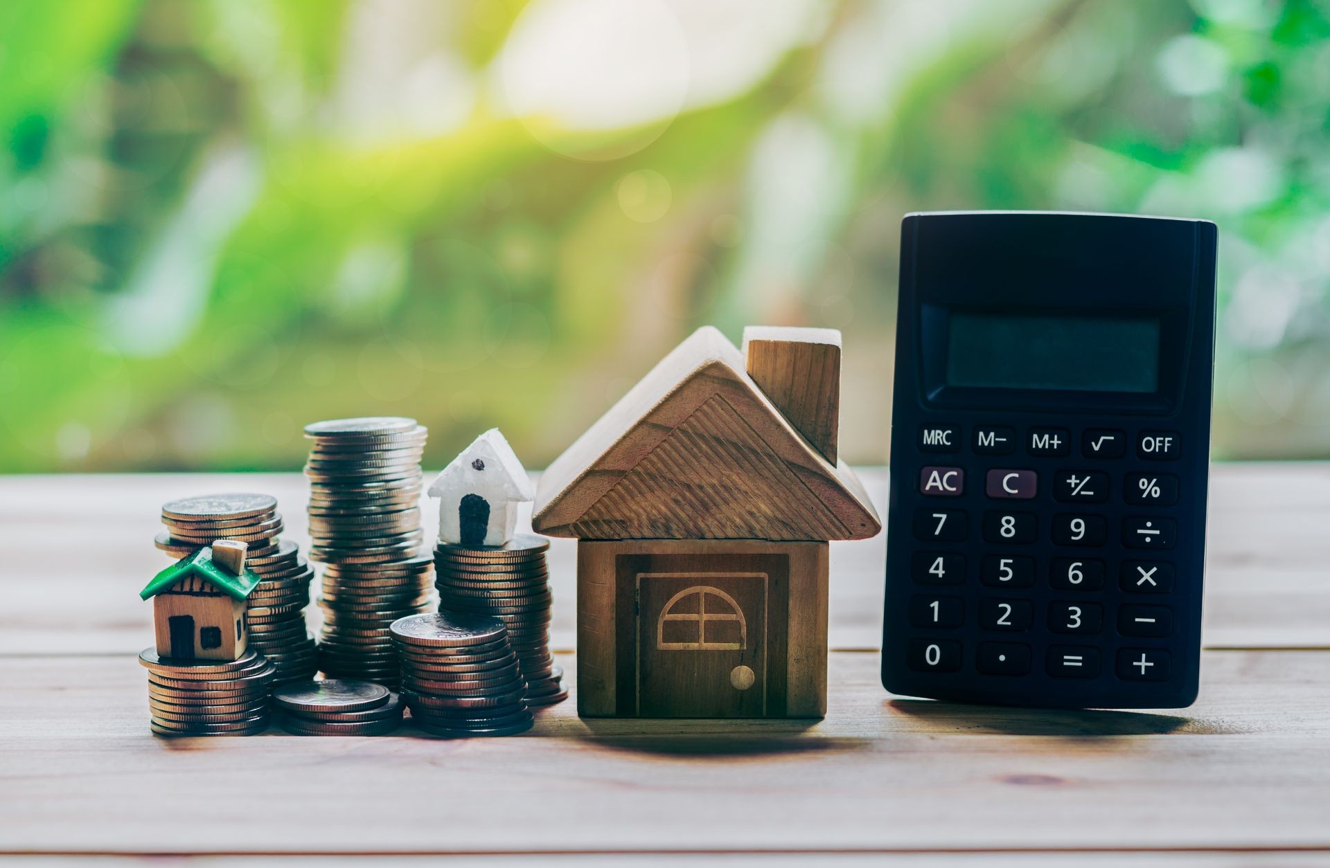 House placed on coins and calculator is on the wood. planning savings money of coins to buy a home concept concept for property ladder, mortgage and real estate investment. for saving for a house.